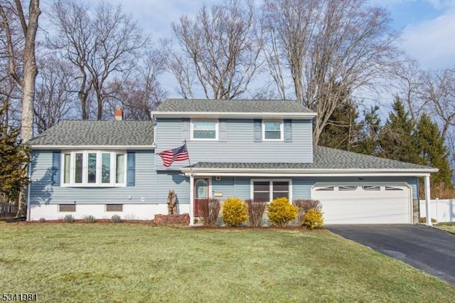 tri-level home featuring a chimney, aphalt driveway, crawl space, an attached garage, and a front lawn