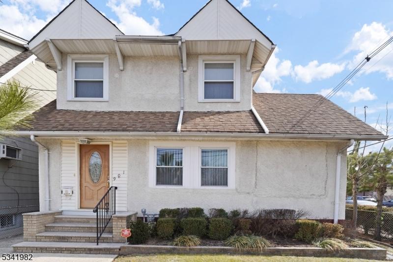 view of front facade featuring entry steps, fence, and stucco siding