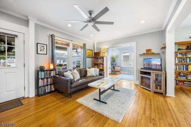 living room featuring recessed lighting, light wood-type flooring, ornamental molding, and a ceiling fan