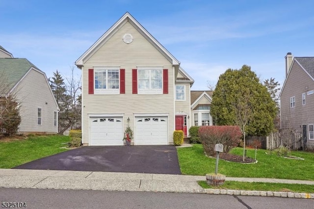 traditional-style house featuring a garage, a front lawn, and aphalt driveway