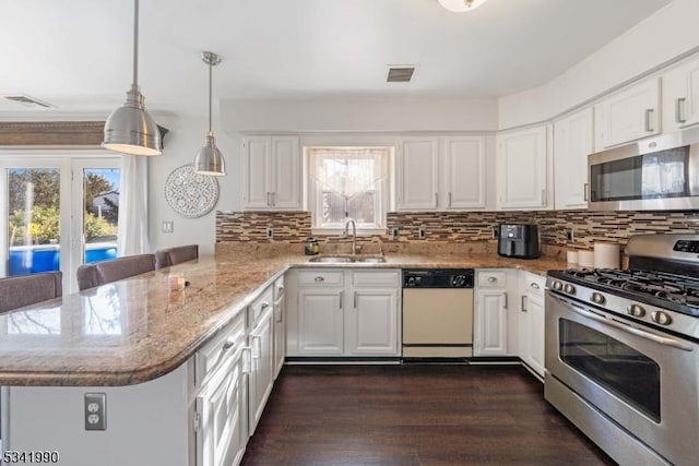 kitchen with visible vents, white cabinets, appliances with stainless steel finishes, a peninsula, and a sink