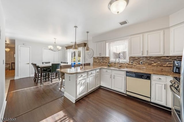 kitchen with a chandelier, a peninsula, white cabinets, dishwasher, and dark wood finished floors