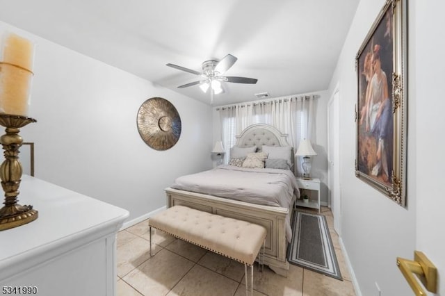 bedroom featuring baseboards, visible vents, a ceiling fan, and light tile patterned flooring