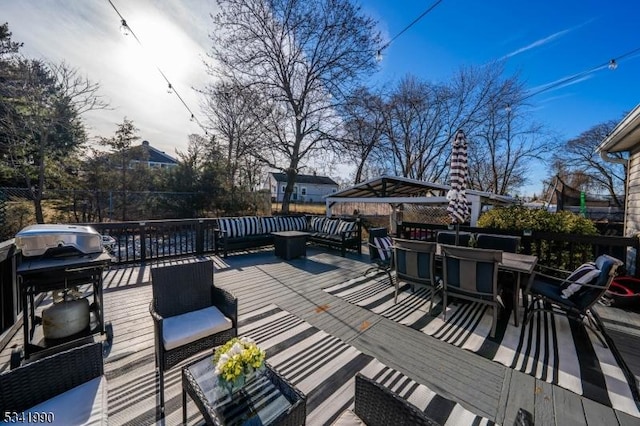 deck featuring a gazebo, outdoor dining area, a grill, and fence