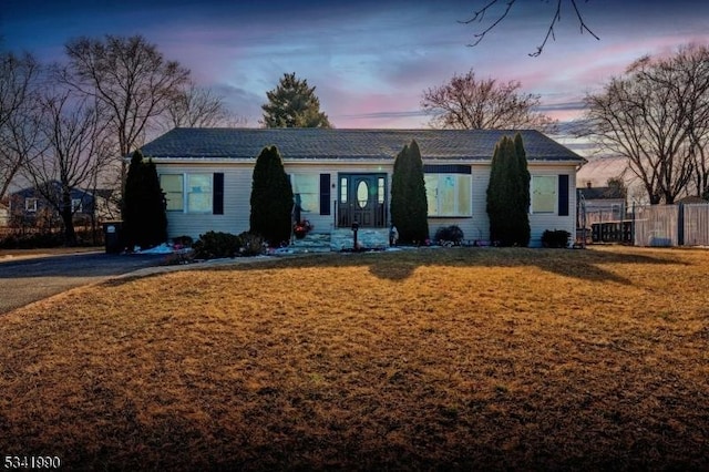 single story home with a front yard and fence