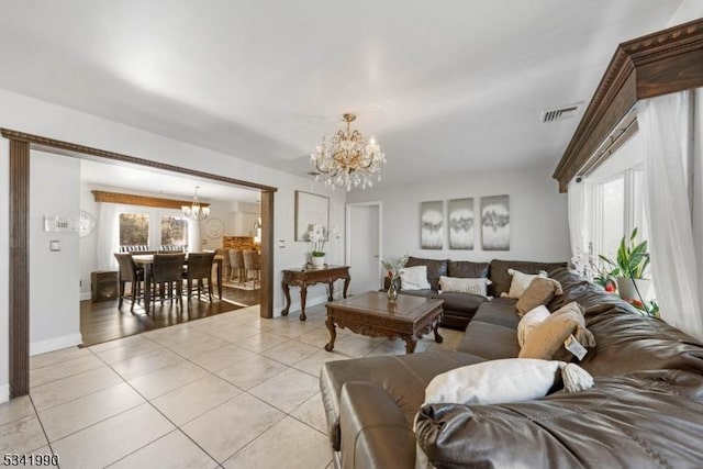 living room featuring light tile patterned floors, a wealth of natural light, visible vents, and an inviting chandelier