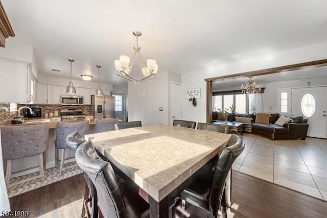 dining room featuring an inviting chandelier and dark wood-type flooring