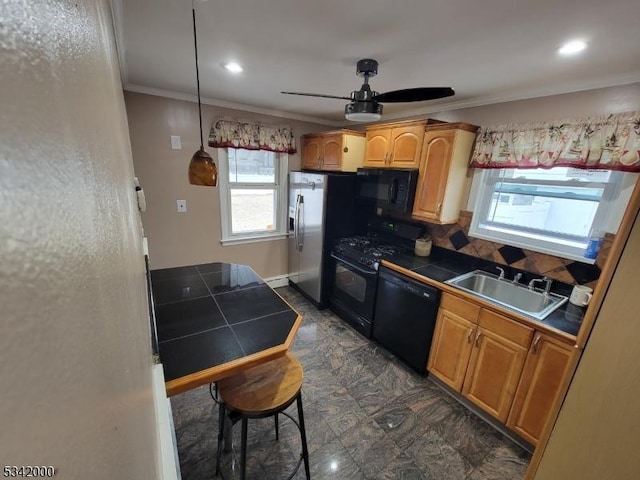 kitchen with tile countertops, ceiling fan, a sink, black appliances, and crown molding