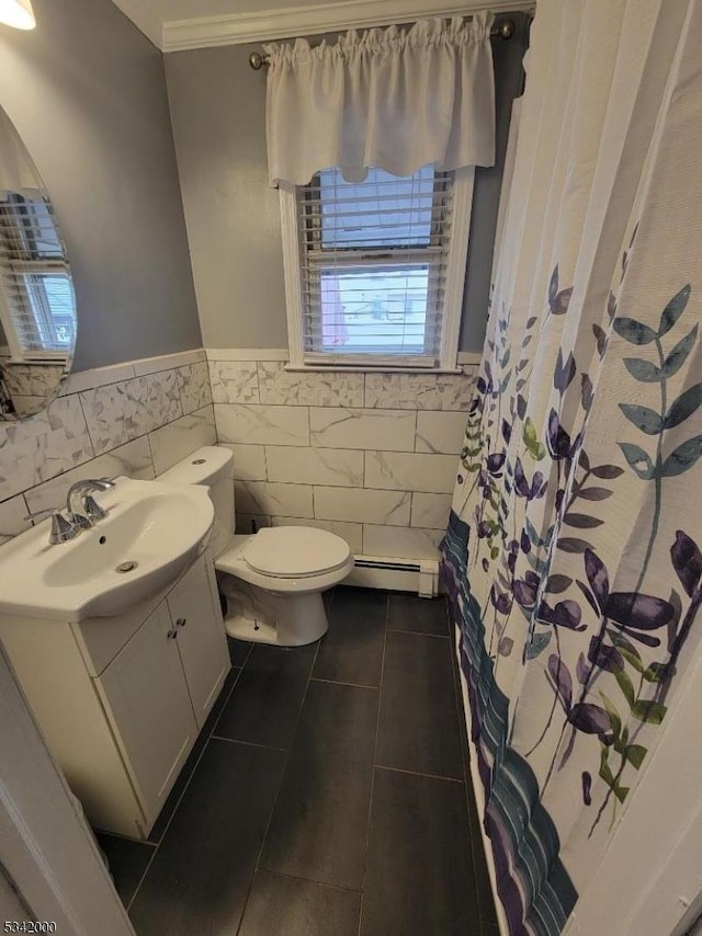 bathroom featuring tile walls, toilet, baseboard heating, vanity, and tile patterned flooring