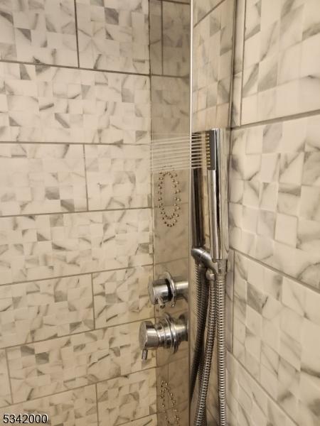 interior details featuring tiled shower