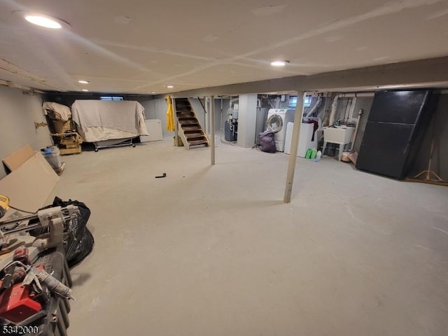 unfinished basement with separate washer and dryer, stairway, and a sink