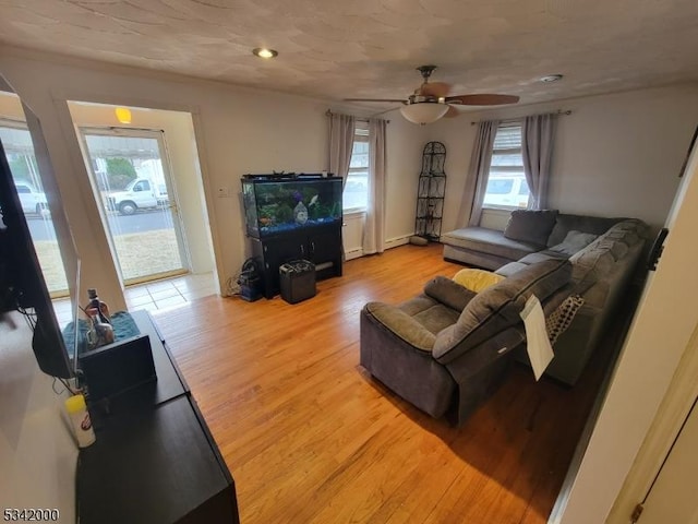 living area featuring plenty of natural light, ceiling fan, and wood finished floors