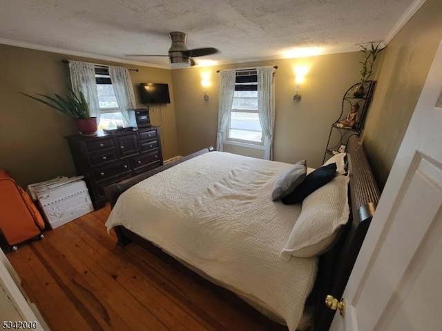 bedroom featuring multiple windows, crown molding, and wood finished floors