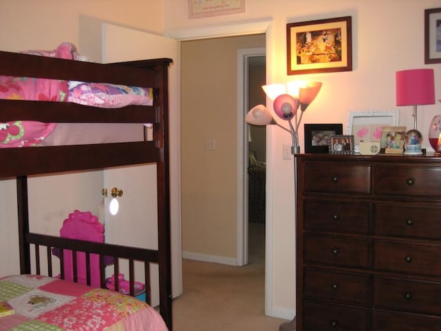 bedroom with light carpet and baseboards