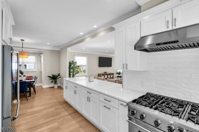 kitchen with stainless steel appliances, a wealth of natural light, white cabinetry, and under cabinet range hood