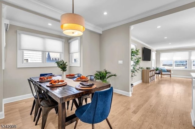 dining room with ornamental molding, a healthy amount of sunlight, and light wood-style flooring