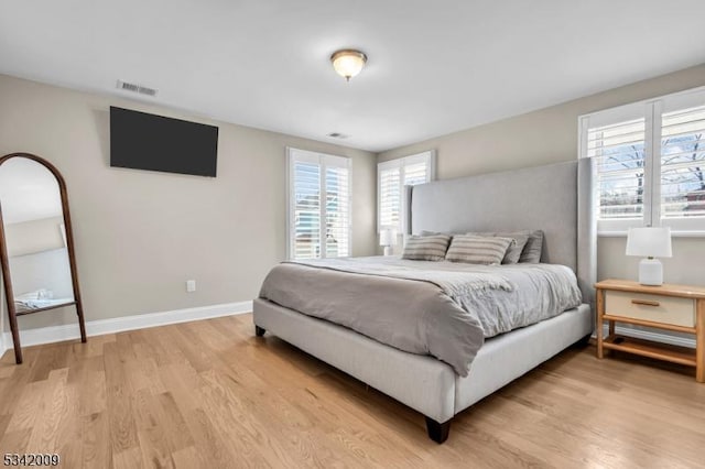 bedroom featuring light wood-type flooring, baseboards, and visible vents