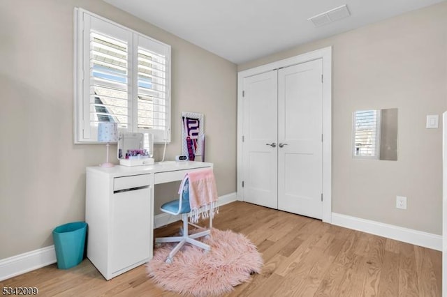 home office featuring baseboards, visible vents, and light wood-style floors