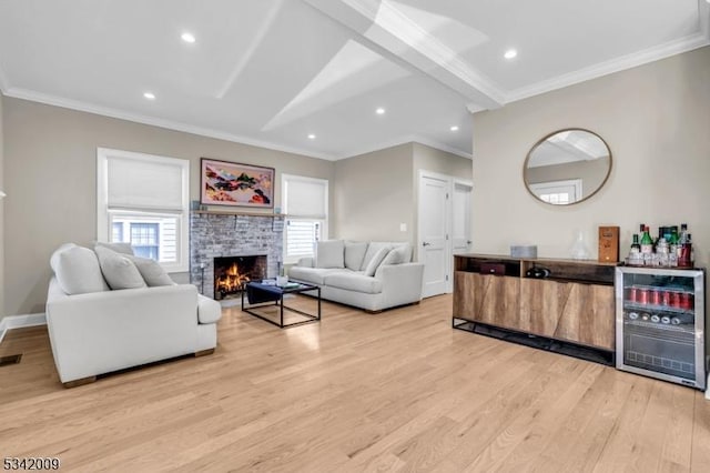 living room with baseboards, light wood-style floors, wine cooler, crown molding, and a brick fireplace