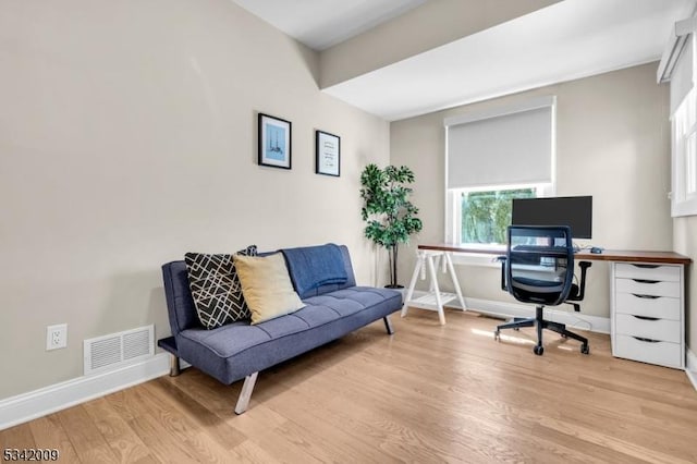 home office featuring light wood-style flooring, visible vents, and baseboards