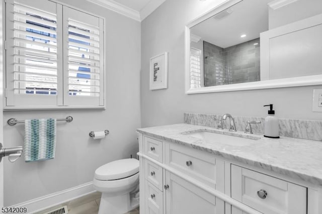 bathroom featuring toilet, vanity, baseboards, a tile shower, and crown molding