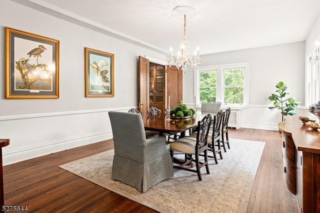 dining space with a chandelier and wood finished floors