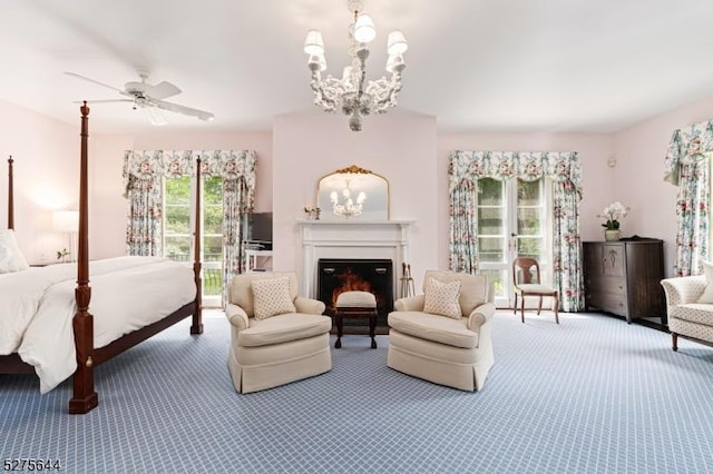 carpeted bedroom featuring a notable chandelier and a lit fireplace