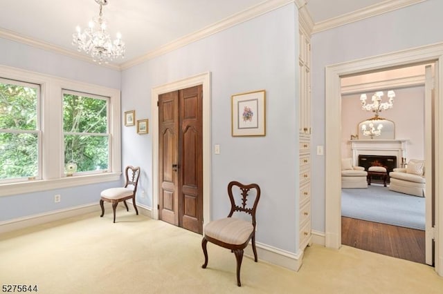 sitting room with crown molding, carpet, a fireplace, and an inviting chandelier