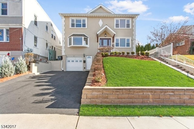 view of front of house featuring aphalt driveway, a front lawn, fence, and stucco siding