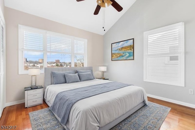 bedroom with vaulted ceiling, ceiling fan, wood finished floors, and baseboards