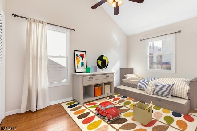 playroom featuring high vaulted ceiling, ceiling fan, baseboards, and wood finished floors