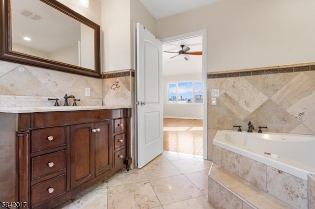 full bath with visible vents, tile walls, vanity, a bath, and tile patterned floors