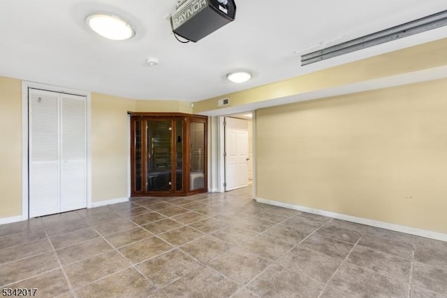 tiled spare room featuring baseboards