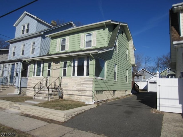 view of front facade with driveway and a gambrel roof