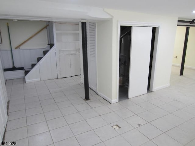 interior space featuring light tile patterned floors, baseboards, and stairway