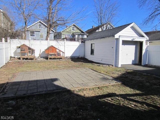 view of yard with an outbuilding, a fenced backyard, and a garage