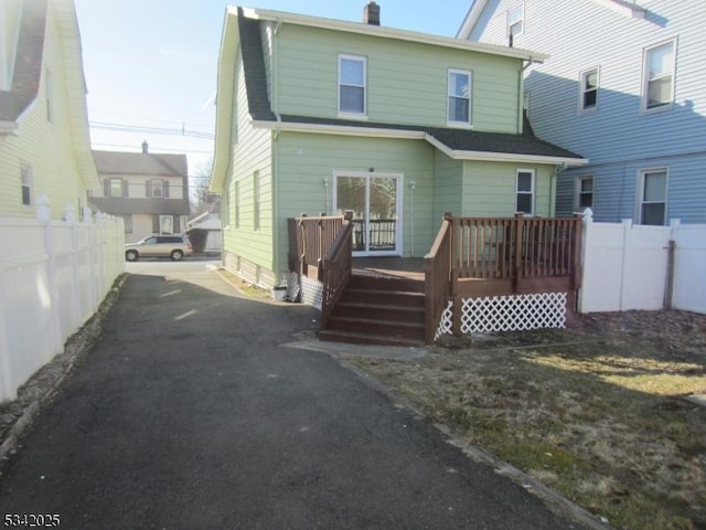 back of house with fence, driveway, and a wooden deck