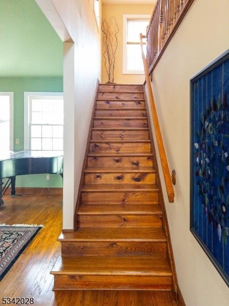 stairs with wood finished floors and baseboards