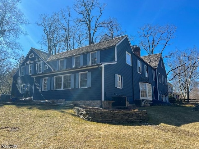 exterior space with a yard, central AC, and a chimney