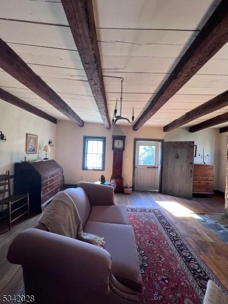 living room featuring beam ceiling and wood finished floors