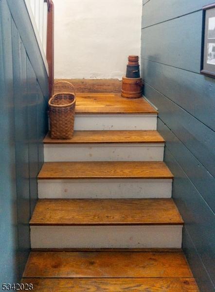 staircase featuring wood walls