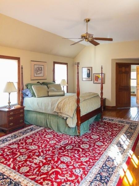 bedroom featuring multiple windows, wood finished floors, a ceiling fan, and vaulted ceiling