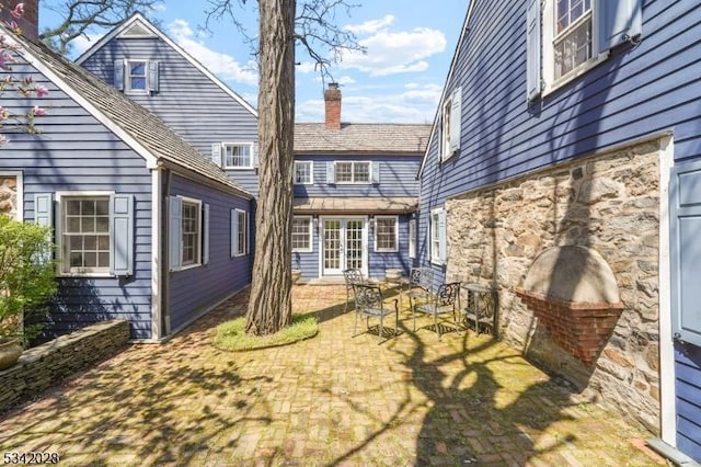 rear view of house with a patio area and a chimney