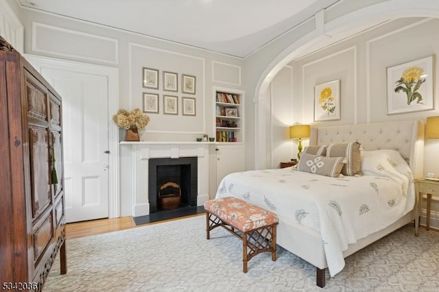 29 Kitchell Rd, Morris Twp, NJ 07960 - bedroom featuring arched walkways, a fireplace with flush hearth, and light wood-type flooring