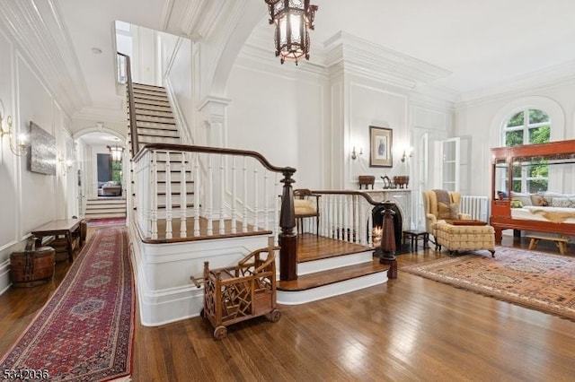 29 Kitchell Rd, Morris Twp, NJ 07960 - staircase featuring arched walkways, wood finished floors, a decorative wall, and crown molding