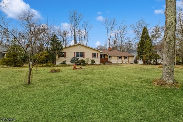 rear view of house with a lawn and a chimney