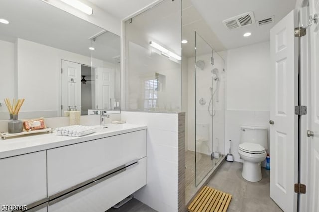 full bathroom with toilet, a shower stall, visible vents, and vanity