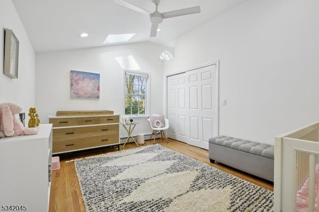 bedroom with ceiling fan, recessed lighting, a closet, light wood-type flooring, and lofted ceiling with skylight