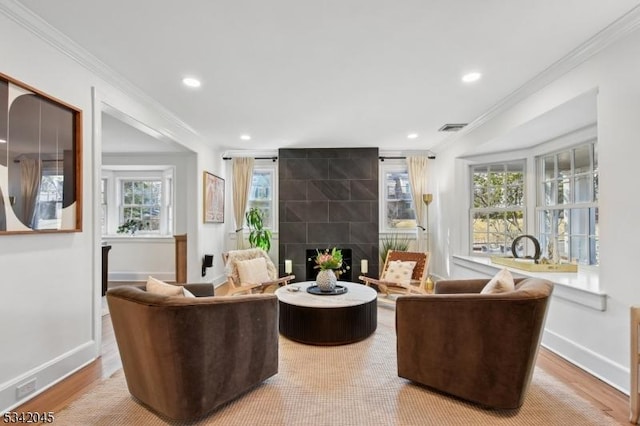 living area featuring baseboards, ornamental molding, and wood finished floors