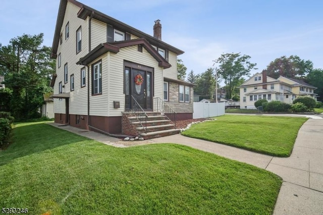 view of front of home with a chimney and a front yard